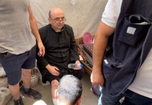 Župnik Župe Svete Obitelji u Gazi o. Gabriele Romanelli, dobiva medicinsku pomoć nakon izraelskog napada.
